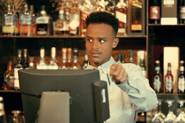 serveur d'un restaurant qui manipule une caisse enregistreuse tactile